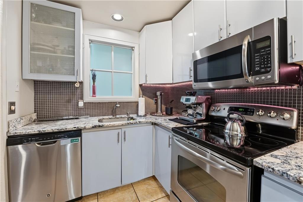 Kitchen with red tile backsplash and white cabinetry