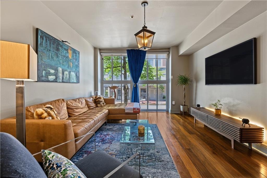 Living room with walnut floors and tall windows